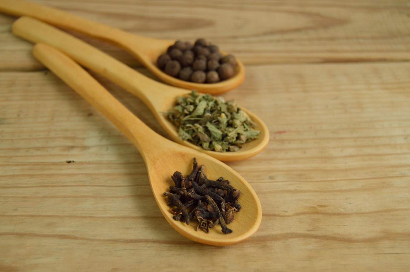Whole cloves on wooden spoon
